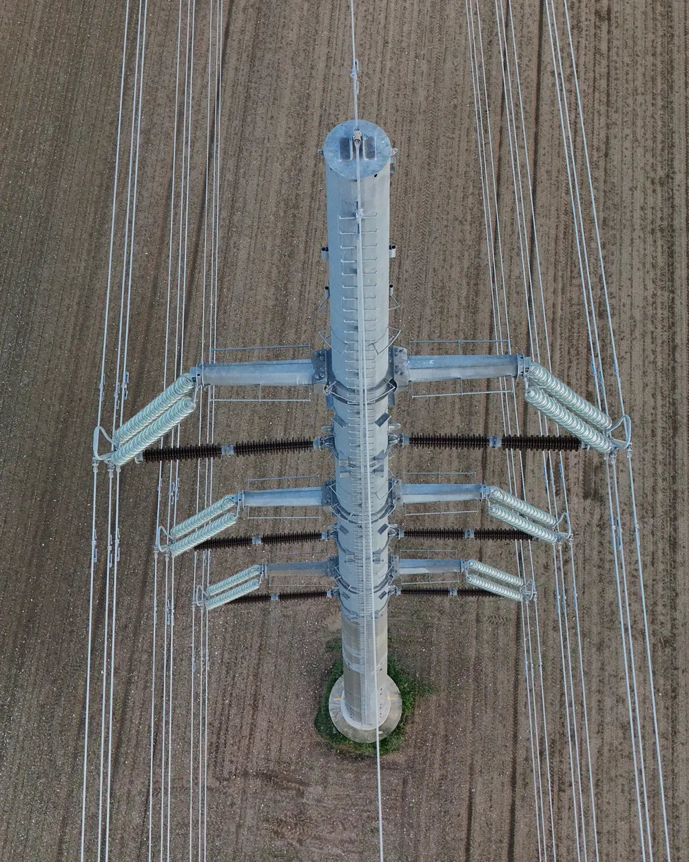 Ispezione zenitale con drone di un sostegno dell'alta tensione su seminativo